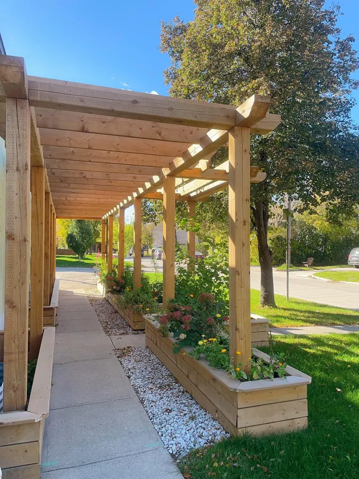 The wooden pergola walkway outside SPA OJAS, with flower boxes